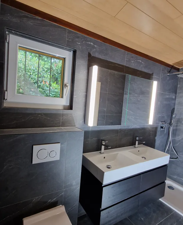 Salle de bains avec double vasque, miroir lumineux et douche